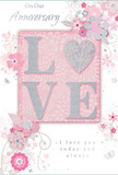 The photograph features a beautifully detailed anniversary card, its design steeped in soft romance and subtle sparkle, much like the gentle charm of the streets around Deptford High Street. At the heart of the card lies the word LOVE, written in prominent, capital letters that are embossed and richly coated with fine glitter. This glitter, shimmering in silvery and blush-pink tones, gives the letters a textured, slightly raised surface that feels luxurious and inviting to the touch. The central word is set upon a blush-pink rectangular panel, slightly distinct from yet harmonising with the surrounding powder-pink background. Surrounding the word, an array of illustrated flowers and leaves appears to drift across the card like a delicate floral breeze. The flowers are rendered in a refined, stylised manner, their petals outlined in soft grey and filled with hues of blush, ivory, and light pink, with glistening hints of silver that catch the eye like fine foil detailing. Curved stems and swirling tendrils weave in and out, forming gentle arcs that frame the central word without overwhelming it, echoing the flowing lines of a florist's hand when arranging a romantic bouquet. The overall background remains a smooth, consistent shade of soft pink, giving a calm, cohesive feel. Small decorative flourishes and scrolls add an extra note of elegance, enhancing the sense of movement and celebration. The anniversary message appears in an elegant script, its flowing letters mirroring the line of the vines and petals. Altogether, the card communicates tenderness, commitment, and quiet joy-an ideal keepsake for honouring shared years, as heartfelt as fresh flowers delivered to a loved one in Deptford.